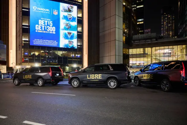 FanDuel digital billboard on Madison Square Garden above the Penn Station entrance, with wrapped SUVs below, New York, 2025