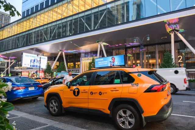 Samsung digital taxi top outside Madison Square Garden with a Bud Light digital billboard behind it, New York, 2025